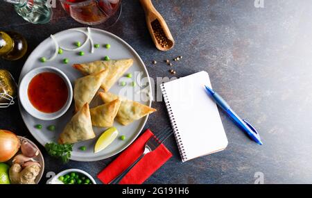 Samosa de légumes maison, nourriture de rue remplie de pommes de terre, oignon, coriandre, petits pois présentés sur une assiette. Banque D'Images