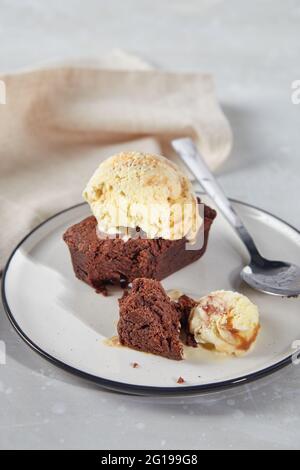 Dessert au chocolat Brownie avec une cuillère de crème glacée crémeuse aux noix sur l'assiette avec serviette. Banque D'Images