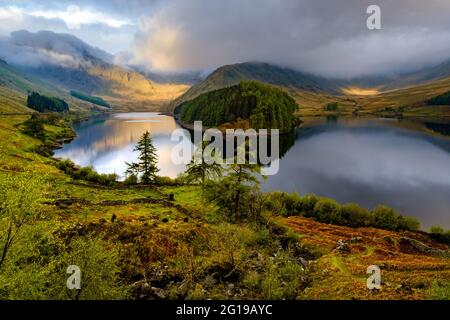 Tôt le matin, le soleil se brisant à travers les nuages au-dessus de Harter est tombé, reflété dans le réservoir de Haweswater dans le district de English Lake Banque D'Images