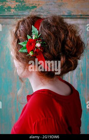 Demoiselle d'honneur portant une fleur de poignet en fleur de rose rouge. Décoration de fête Banque D'Images