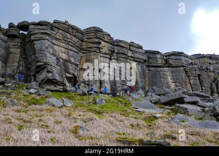 Grimpeurs de roche à la célèbre falaise de pierre à aiguiser de Stanage Edge, Derbyshire, Peak District Banque D'Images