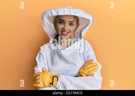 Belle blonde blanche femme portant l'uniforme de gardien de tête de protection visage heureux souriant avec les bras croisés regardant la caméra. Personne positive. Banque D'Images