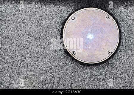 La texture de la surface des restes de marbre finisse le sol et la couverture métallique de l'orifice de service à côté de la piscine Banque D'Images