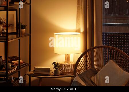 Vue d'un coin lecteur confortable avec une lampe de table qui diffuse une lumière chaude Banque D'Images