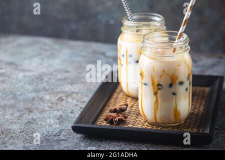 Light Brown bubble tea crème de lait et de tapioca noir dans un bocal en verre sur fond gris Banque D'Images