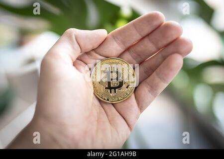 Pièce physique Bitcoin tenue à la main. Banque D'Images