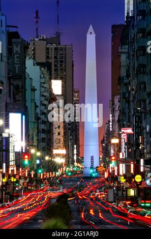 Vue de loin de l'Avenue Corrientes, à l'Obélisque Monument et de voitures, la nuit, avec des feux du véhicule sous forme de lignes. Buenos Aires, Argentine Banque D'Images