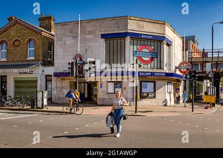 Une femme traversant la route à l'extérieur de la station de métro Balham dans le sud de Londres, la station Balham se trouve sur la ligne de métro Northern et Southern National Rail Banque D'Images