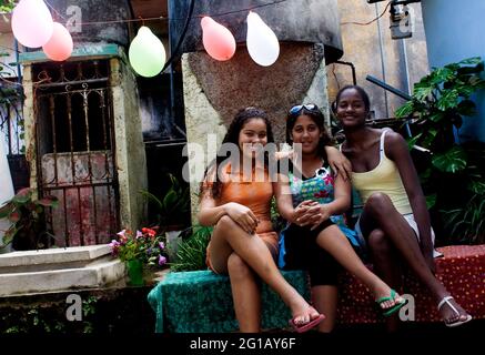 Jeunes filles posant devant l'appareil photo. La ville de la Havane, 50e anniversaire de la révolution socialiste. Cinquante ans depuis la chute du gouvernement Batista. Tout comme l'État révolutionnaire socialiste, sous les troupes de Fidel Castro, Che Guevara et Camilo Cienfuegos. En 2009, alors que la société cubaine reste en constante adaptation et que le régime est entré dans une nouvelle période post-soviétique sociale et économique, Cuba reflète la nécessité de changements révolutionnaires actuels. La Havane, Cuba. 31 décembre 2008. Banque D'Images