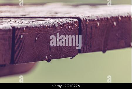 Chute sur une table de jardin en bois sous une chaude pluie d'été - jour d'été à la pluie dans le jardin - Table de jardin sous la pluie. Banque D'Images