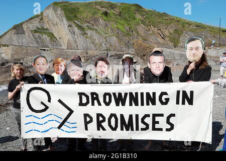 Ilfracombe, North Devon, Royaume-Uni. 6 juin 2021. Extinction les manifestants de la rébellion ont organisé une protestation arrosée dans la ville balnéaire d'Ilfracombe pour mettre en évidence les dangers potentiels de l'élévation du niveau des mers dans la région si la crise climatique n'est pas traitée. Le groupe de manifestants s'est habillé comme les leaders du G7 alors que la marée est arrivée et les a encerclés. Crédit : Natasha Quarmby/Alay Live News Banque D'Images