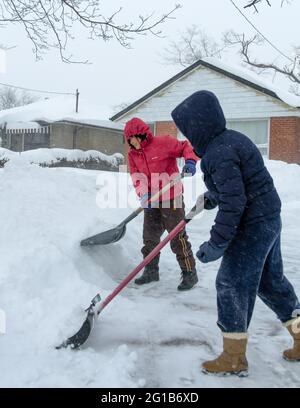 La famille ou les personnes qui défrivent le trottoir de neige pendant l'hiver violent en raison du vortex polaire ou de la tempête qui a frappé Toronto en 2014. Banque D'Images