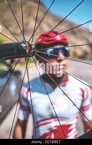 Portrait du jeune cycliste avec son vélo sur la route. Sport concept, mise au point sélective Banque D'Images