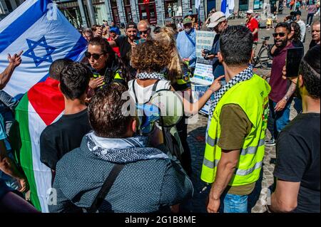 Les manifestants brandient des drapeaux et des slogans lors d'une manifestation pro-palestinienne sur la place du Dam à Amsterdam.lors d'une manifestation pro-palestinienne organisée sur la place du Dam à Amsterdam par la communauté palestinienne aux pays-Bas, Des conflits se sont produit entre les Palestiniens et certains Israéliens qui manifestaient en même temps et au même endroit. Certains d'entre eux ont été blessés au cours des combats et des arrestations ont été effectuées par la police néerlandaise. Après cela, la manifestation Pro Palestine s'est déroulée sans autre problème. Banque D'Images