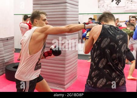 Belarus, Minsk - 07 mars 2020 : un jeune sportif en gants de boxe est en boxe avec un partenaire dans une salle de sport. Banque D'Images