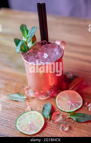 Du dessus de la tasse de cuivre avec le cocktail Moscou Mule fait avec de la vodka, de la bière épicée au gingembre et du jus de citron vert recouvert de feuilles de menthe Banque D'Images