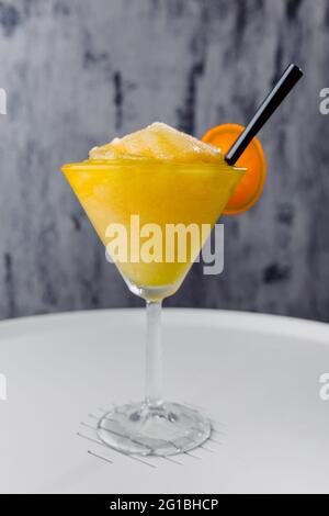 Un verre de cocktail Daikiri Maracuya sucré à base de jus de citron vert et de sucre au rhum accompagné de fruits de la passion sur la table Banque D'Images