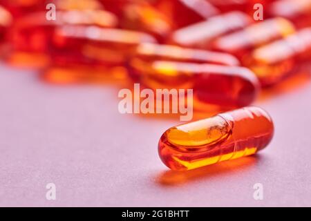 Composition de pilules d'orange dispersées sur fond rose en studio léger Banque D'Images