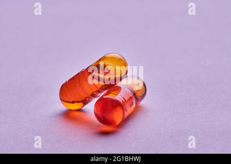 Composition de pilules orange sur fond rose en studio léger Banque D'Images