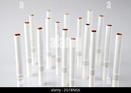 Gros plan d'une pile de cigarettes sur fond blanc Banque D'Images