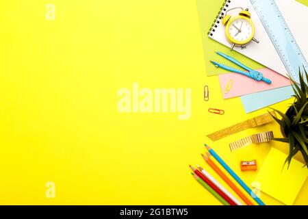 Concept de retour à l'école. Fournitures scolaires fixes colorées sur fond jaune, espace ou texte à plat Banque D'Images