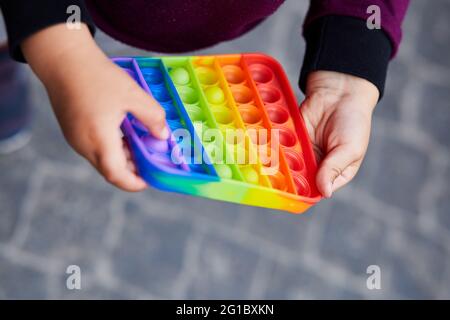 Violon sensoriel Rainbow. Nouveau jouet en silicone tendance. Le jouet sensoriel antistress coloré de jeu de violon pousser dans les mains des enfants. Jouet pop IT tendance antistress. Photo de haute qualité Banque D'Images