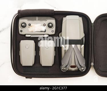Quadcopter à bourdonnement pliable avec jeu complet en étui. Vue de dessus ou plan de travail. Kit de drone UAV et accessoires - contrôleur et deux bataillons en cas sur fond de marbre blanc Banque D'Images