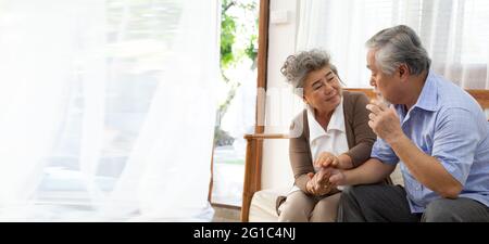 Couple asiatique senior retraité tenant la main et prendre soin ensemble à la maison, la maladie d'Alzheimer ou souffrant de démence concept Banque D'Images