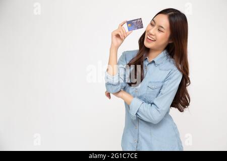 Portrait d'une jeune femme heureuse tenant ATM ou carte de débit ou de crédit et utilisant pour le shopping en ligne dépensant beaucoup d'argent isolé sur backgrou blanc Banque D'Images