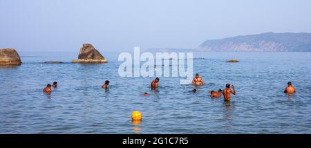 Groupe de mâles indiens se baignant dans la belle mer bleue, Agonda, Goa, Inde Banque D'Images