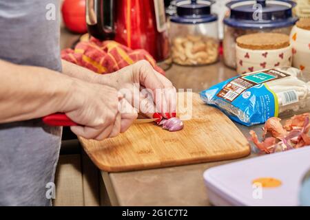 La femme coupe un oignon pour cuisiner du poisson avec des champignons et des crevettes, recette étape par étape de l'Internet Banque D'Images