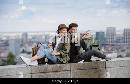 Jeunes voyageurs en couple avec carte dans la ville sur les vacances, repos et planification. Banque D'Images