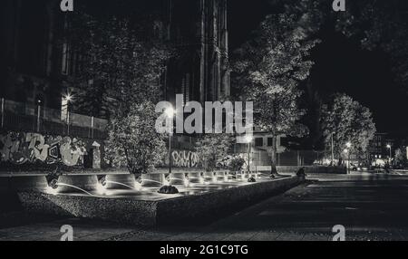 Au coeur de la Ruhr dans le centre ville d'Essen la nuit, dans une chaude soirée de fin d'été. Café Nord à l'église Saint-Gertrud à la fontaine. Banque D'Images