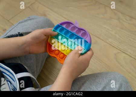 Silicone jouet antistress pop. Nouvelle tendance. Jouet de capteurs colorés dans les mains de garçon Banque D'Images