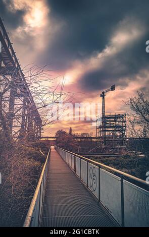 Promenade en métal et en acier sur l'Emscher en perspective centrale. Parc paysager de Duisburg. Machines industrielles et composants rouillés dans la région de Ruhr. Banque D'Images