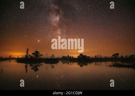 Marais marécageux marais marais marais marais marais marais marais lac marécageux nature nuit Paysage. Nuit Starry Sky Milky Way Galaxy avec étoiles et lune brillantes. Reflet du ciel de nuit dans Banque D'Images