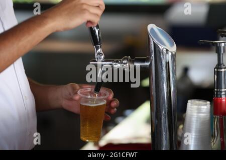 Le barman verse la bière froide de la machine dans le verre. Banque D'Images