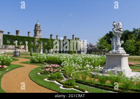 Jardins italiens à Wrest Park, Royaume-Uni ; statues en premier plan avec la demeure majestueuse en arrière-plan. Silsoe, Bedfordshire, Royaume-Uni Banque D'Images