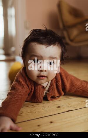 Portrait de bébé garçon couché sur le sol à la maison Banque D'Images