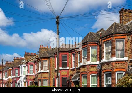 Une rangée de maisons en terrasse typiquement anglaises autour de Kensal s'élèvent à Londres avec des lignes de câble aériennes Banque D'Images