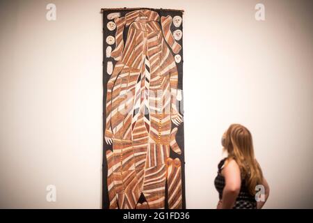 Un membre du personnel regarde Buluwana, ancêtre féminin 1989 de John Mawurndjul, un tableau sur l'écorce qui est un matériel utilisé par les Kuninkju à des fins pratiques et cérémonielles, sur l'exposition GRATUITE A Year in Art: Australia 1992 à Tate Modern, Londres. Date de la photo: Lundi 7 juin 2021. Banque D'Images