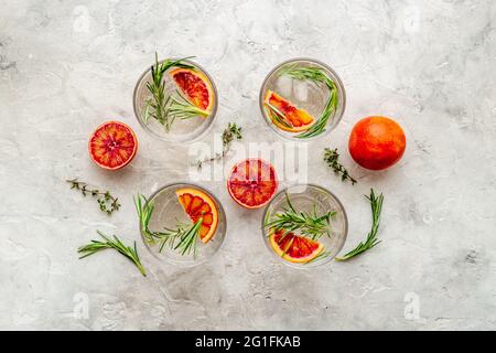 Limonade orange rouge en verres avec glace et romarin Banque D'Images
