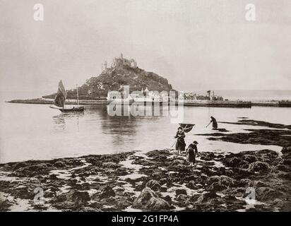 Vue de la fin du XIXe siècle sur les femmes qui pêchent des crevettes dans la baie de Mounts, en face du mont St Michael's, en Cornouailles, en Angleterre. Le Mont a peut-être été le site d'un monastère du 8 au début du XIe siècle, quand Edward le confesseur a offert le site à l'ordre bénédictin du Mont Saint-Michel. Elle devint prieuré de cette abbaye jusqu'à la dissolution des maisons exotiques comme effet secondaire de la guerre en France par Henri V, mais demeura une destination pour les pèlerins, dont les dévotions furent encouragées par une indulgence accordée par le Pape Grégoire au XIe siècle. Banque D'Images