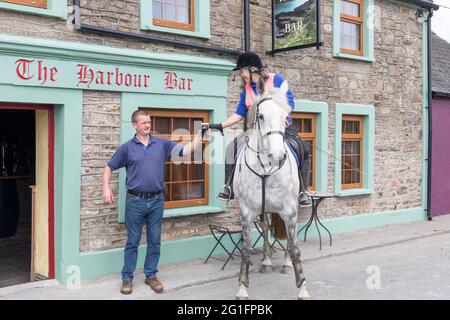 Roberts Cove, Cork, Irlande. 07e juin 2021. Avec l'entrée en vigueur de l'assouplissement des restrictions Covid-19, le public Frank Walsh sert une pinte de crème à son premier client en six mois Imogen Bertin et son cheval Hatbox lorsqu'ils ont appelé au bar de la baie de Roberts Cove, Co. Cork, Irlande. - crédit; David Creedon / Alamy Live News Banque D'Images