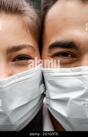 vue rognée d'un jeune homme et d'une jeune femme dans des masques médicaux regardant l'appareil photo Banque D'Images