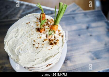 Gâteau aux carottes avec glaçage blanc garni de carottes fraîches. Vue de dessus Banque D'Images