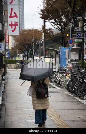 OSAKA, JAPON - 06 décembre 2019 : Osaka, Japon - 02 décembre 2019 : femmes avec parapluie dans la rue pendant les jours de pluie Banque D'Images