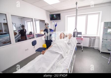 Patient adulte allongé sur le lit lors d'une injection intraveineuse en déposant une bouteille dans la clinique de l'hôpital Banque D'Images