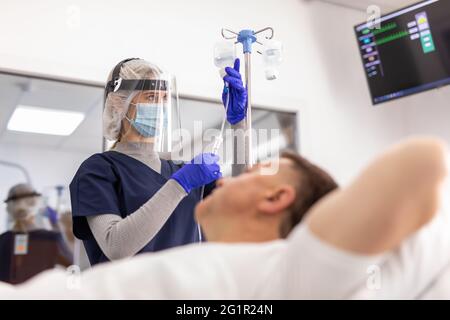 Patient adulte allongé sur le lit lors d'une injection intraveineuse en déposant une bouteille dans la clinique de l'hôpital Banque D'Images