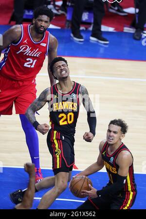 Philadelphie, États-Unis. 06e juin 2021. L'avant des Hawks d'Atlanta John Collins (au centre) réagit après avoir claqué deux points et tiré la faute de Philadelphie 76ers centre Joel Embiid (à gauche) sur un passe lob au panier de Trae Young (à droite) pendant les dernières secondes d'une victoire de 128-124 Hawks dans une deuxième ronde de la NBA Eastern Conference Jouez au basket-ball le dimanche 6 juin 2021 à Philadelphie. (Photo de Curtis Compton/Atlanta Journal-Constitution/TNS/Sipa USA) crédit: SIPA USA/Alay Live News Banque D'Images